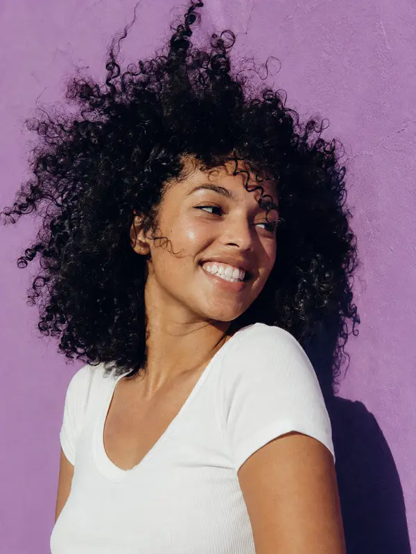 Client wearing defined natural curls with a rounded shape